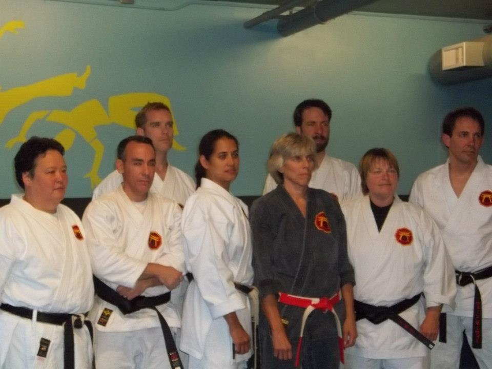 Students in uniform by the dojo's mural wall