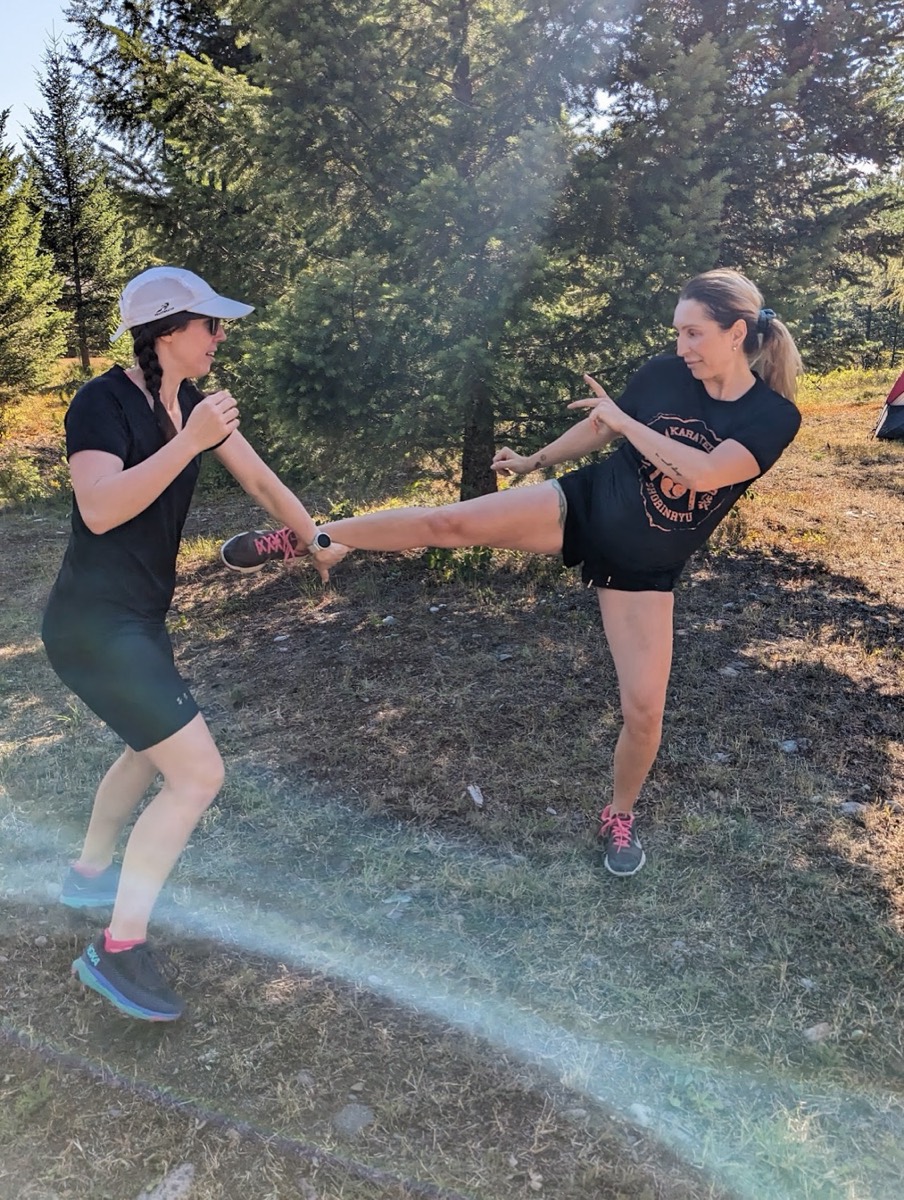 Two students practicing a kick outdoors